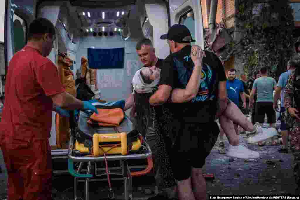 Рятувальники переносять постраждалу жінку до карети швидкої допомоги, Покровськ, 7 серпня 2023 року