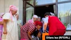 Бир нече жолу эсин жоготкон кыздын энесине "Тез жардам" кызматынын медиктери алгачкы жардамды көрсөтүп жатышты.