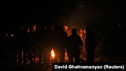 Nagorno-Karabakh - Refugees gather around a fire to warm themselves as they stuck in a jam of vehicles on the road leading towards the Armenian border, September 25, 2023.