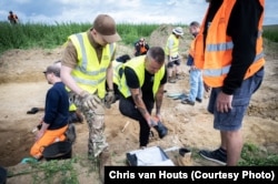 Олексій одягає спеціальні чоботи, перш ніж приступати до розкопок