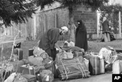 برخی همراهان روح‌الله خمینی ازجمله هادی غفاری در باغ محل اقامت او در نوفل لوشاتو در حال جمع‌آوری وسایل پیش از پرواز به سمت تهران