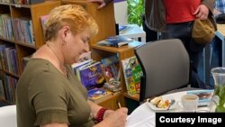 Галіна Максімюк падпісвае кніжку на аўтарскай сустрэчы ў Орлі, травень 2023