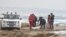 Rescue workers recover a body after a suspected migrant boat was shipwrecked off the coast of southern Italy. 
