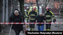 Spasioci pomažu pri evakuaciji ljudi iz stambene zgrade oštećene tokom ruskog raketnog napada na Kijev 21. marta.