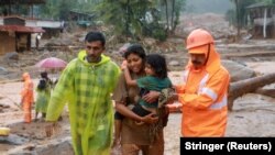 Индияда жер көчкүдөн аман калгандарды куткаруучулар жетелеп баратышат. 30-июль, 2024-жыл. 