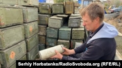 Фермер Володимир демонструє російську протипіхотну міну ПОМ-3, яку він дістав зі свого поля у селі Кам'янка