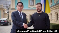 Japanese Prime Minister Fumio Kishida (left) and Ukrainian President Volodymyr Zelenskiy greet each other during a meeting in Kyiv on March 21.
