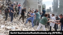 Волонтери, медперсонал та рятувальники розбирають завали одного з корпусів лікарні «Охматдит» у Києві після влучення туди російської ракети. Україна, 8 липня 2024 року