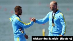 Золоті медалісти з України Олег Кухарик (ліворуч) та Ігор Трунов святкують перемогу у фіналі чоловічої байдарки-двійки на 500 метрів