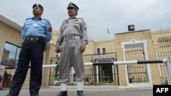 Pakistani policemen stand in front of the Election Commission of Pakistan (ECP) office in Islamabad. 