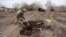 A Ukrainian serviceman buries the remains of what he said was the dead body of a Russian soldier in a village near Kyiv that was reclaimed by Ukraine in March 2022. 