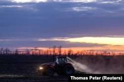 Трактор оре поле під час заходу сонця поблизу Покровська, на тлі нападу Росії на Україну, 7 квітня 2024 року