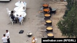 Aşgabadyň etrapçalarynyň birindäki meýdançada uly gazanlarda nahar bişirýän ýaşaýjylar (Illýustrasiýa suraty)