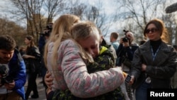 کودک ۱۳ ساله اوکراینی هنگام بازگشت از روسیه به کی‌یف، مادر خود را در آغوش کشیده است