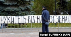 Транспарант із написом «Руки геть від нашої землі!» біля парламенту України під час територіального конфлікту з Росією, яка здійснювала будівництво дамби до українського острова Тузла. Київ, 22 жовтня 2023 року