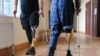 Ukrainian soldiers with prosthetic legs walk with crutches at a rehabilitation center near Lviv in western Ukraine.