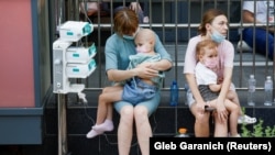 Жінки тримають пацієнтів дитячої лікарні «Охматдит», яка постраждала під час російських ракетних ударів на Україну, Київ, Україна, 8 липня 2024 року