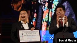 "Бороондуу бекет", "Ак кеме" спектаклдери менен жеңишке жеткен Уланмырза Карыпбаевге сыйлык тапшырылып жатат.