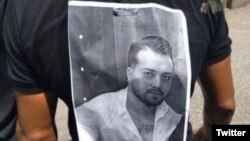 تصویر مهران سماک، معترض کشته شده به دست نیروهای امنیتی، بر پشت یکی از حاضران در مراسم عاشورای بندرانزلی