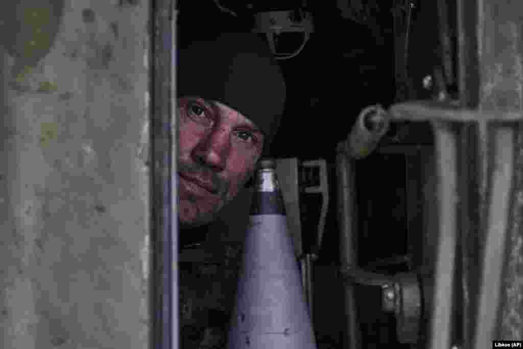 Український військовий визирає із самохідної гаубиці