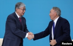 Қазақстанның бұрынғы президенті Нұрсұлтан Назарбаев (оң жақта) пен оның орнына келген Қасым-Жомарт Тоқаев биліктегі NurOtan партиясы съезінде. Нұр-Сұлтан (қазіргі Астана), 23 сәуір, 2019 жыл.