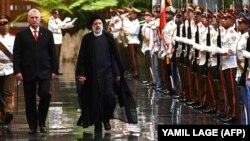 Cuban President Miguel Diaz-Canel (left) and Iranian President Ebrahim Raisi review an honor guard during a welcoming ceremony in Havana on June 15.