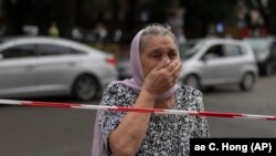 Одессадагы орус армиясынын соккуларынан жабыркаган имараттын алдында турган аял. 23-июль, 2023-жыл. Архив сүрөт.

