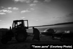 Father Mikhail helps launch a boat.