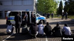 Germaniýa-Polşa serhedinde nemes polisiýasy tarapyndan saklanan bikanun migrantlar. Illýustrasiýa suraty. Arhiwden alyndy.