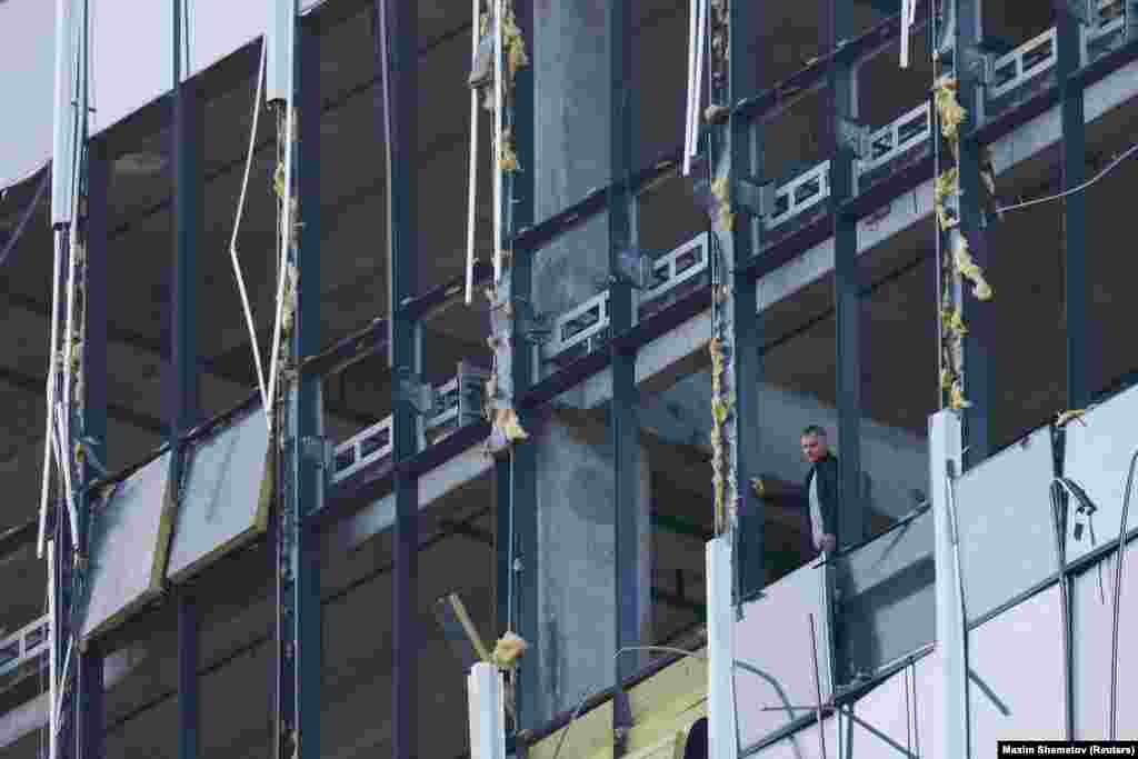 A member of the security services investigates a damaged building following a reported drone attack in Moscow on July 24. Russia said it had neutralized two Ukrainian drones over Moscow in the early hours of July 24, with one crashing close to the Defense Ministry in the city center. There were no reported injuries in the attack. &nbsp;