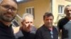 Fatmir Haxholli (left), the secretary of Kosovo's Liaison Office in Belgrade, with the three released Kosovar police officers on June 26. 