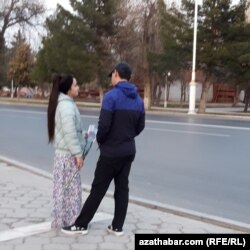 Elinde gül dessesi saklaýan gyz we oglan