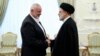 In this photo released by the Iranian president's office, President Ebrahim Raisi (right) greets the leader of the Palestinian militant group Hamas, Ismail Haniyeh, in Tehran on June 20.