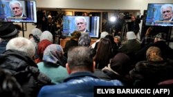 Боснійські мусульмани, які вижили після різанини в Сребрениці, дивляться пряму трансляцію оголошення остаточного вироку у справі Радована Караджича, Поточари (біля меморіалу у Сребрениці), 20 березня 2019 року