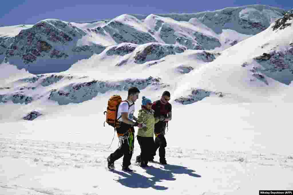 Волонтёры помогают 43-летней Милене Велковской, человеку с церебральным параличом, подняться в горы в массиве Рила на западе страны. 23 марта 2024 года. Это часть путешествия, организованного&nbsp;фондом Ela I Ti с целью помочь пятерым жителям с тяжёлыми формами инвалидности добраться до одного из озёр знаменитого горного хребта. В экспедиции было задействовано 50 волонтёров