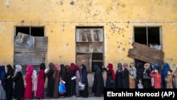Afghan women wait to receive food rations distributed by a humanitarian aid group in Kabul, Afghanistan, late last month. 