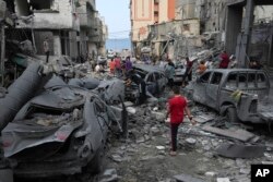 Палестинці в смузі Газа біля зруйнованої авіаударом мечеті в місті Газа. 9 жовтня 2023 року