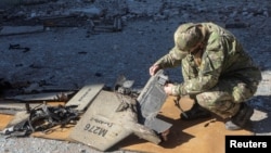 یک سرباز اوکراینی در حال بررسی یک پهپاد «شاهد» ساخت ایران که رهگیری و منهدم شده است