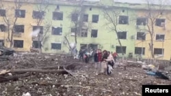 Маріуполь. Люди виводять поранених із дитячої лікарні та пологового, куди влучила російська бомба. 9 березня 2022 року