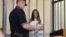 Aleksandra Skochilenko appears in the defendant's cage during her trial in St. Petersburg.