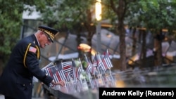 Офіцер поліції у відставці Сем Пулія, який 11 вересня втратив свого двоюрідного брата, встановлює прапорець біля Національного меморіалу та музею 11 вересня в 22-у річницю нападу на Всесвітній торговий центр 11 вересня 2001 року