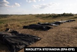 Мішки з тілами на полі, поки члени пошукової групи «Плацдарм» проводять ексгумацію та ідентифікацію тіл загиблих російських військовослужбовців поблизу лінії фронту в районі Бахмуту, Донецька область, Україна, серпень 2024 року