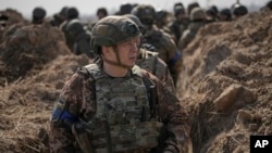 Colonel General Oleksandr Syrskiy walks in a trench at a position north of the capital, Kyiv, in March 2022.