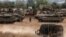 Israeli tanks and militiary vehicles mass at the Israeli side of the Gaza border on October 9.