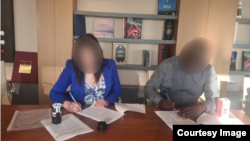 Элнура Суранова кардары менен кагазага кол коюуда