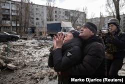 Жінка перед багатоповерхівкою, з якої рятують її брата – будинок був сильно пошкоджений ракетним ударом армії РФ. Покровськ, 15 лютого 2023 року