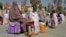 Afghan women sit after receiving food aid distributed by a charity foundation in Kandahar on March 28.