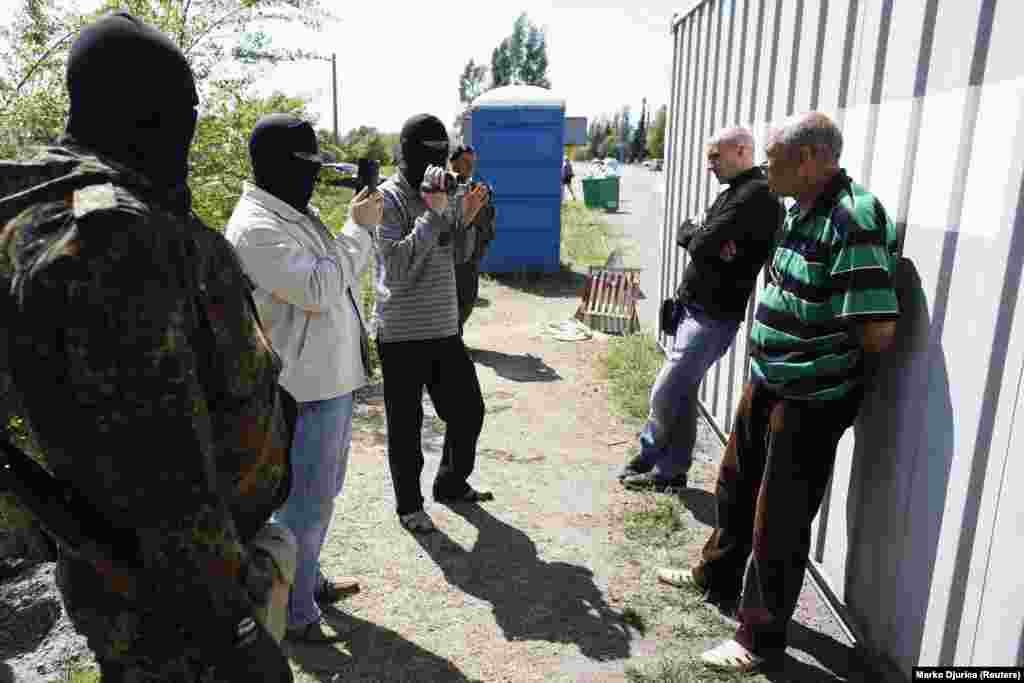 11 травня 2014 року. Українські правоохоронці допитують двох чоловіків на блокпосту під Маріуполем. Ситуація тоді залишалася напруженою, тому по периметру міста встановили пропускні пункти &nbsp;