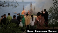 People watch as the building of an educational institution burns after a Russian missile strike on Odesa on April 29.