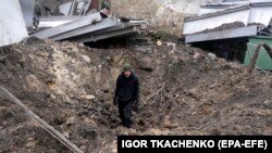A man stands inside a shelling crater following a drone attack in Odesa, southern Ukraine, on December 14. 